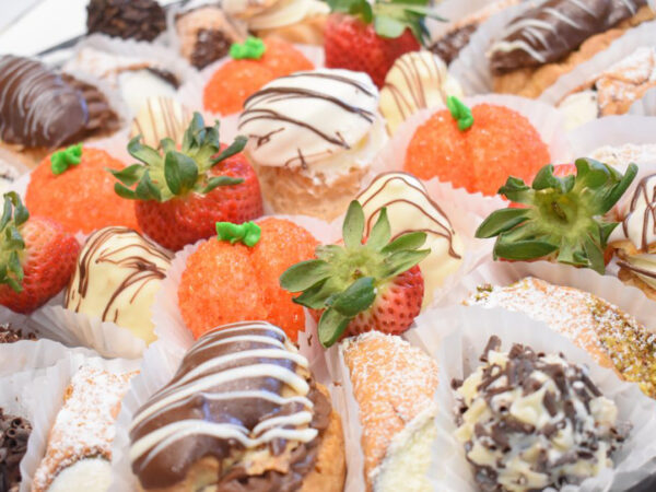 Catering from Goodies Bakeshop Fancy French Pastry Tray: Assortment of cannoli, cream puffs, chocolate eclairs, peaches, truffles and slices